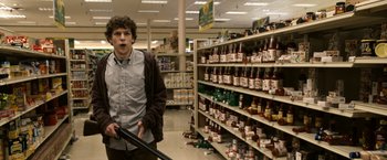 Movie still from “Zombieland” (2009), directed by Ruben Fleischer – A man in a grocery store looking surprised; Medium shot, Over the shoulder angle