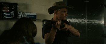 Movie still from “Zombieland” (2009), directed by Ruben Fleischer – A man in a cowboy hat is holding a gun; Medium shot, Over the shoulder angle