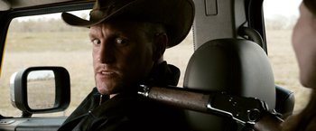 Movie still from “Zombieland” (2009), directed by Ruben Fleischer – A man with a cowboy hat holding a rifle; Close Up shot, Over the shoulder angle