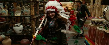 Movie still from “Zombieland” (2009), directed by Ruben Fleischer – A girl in a native american headdress holding a stick; Medium shot, Over the shoulder angle