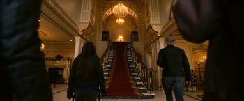 Movie still from “Zombieland” (2009), directed by Ruben Fleischer – Two people walking down a red carpet staircase; Wide shot, Low angle