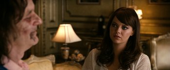 Movie still from “Zombieland” (2009), directed by Ruben Fleischer – A woman sitting in front of a lamp in a living room; Close Up shot, Over the shoulder angle