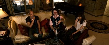 Movie still from “Zombieland” (2009), directed by Ruben Fleischer – A group of people sitting around a living room smoking a hookah pipe; Medium shot, High angle