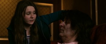 Movie still from “Zombieland” (2009), directed by Ruben Fleischer – A young girl is combing the face of an older woman; Medium shot, Over the shoulder angle