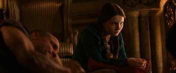 Movie still from “Zombieland” (2009), directed by Ruben Fleischer – A young girl sitting on a couch looking at something; Close Up shot, Over the shoulder angle