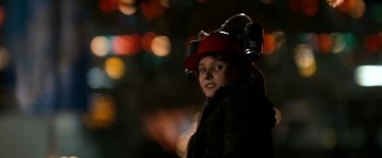 Movie still from “Zombieland” (2009), directed by Ruben Fleischer – A young boy wearing a red hat with lights in the background; Close Up shot, Over the shoulder angle