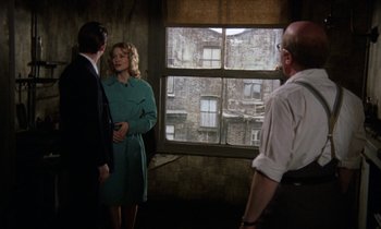 Movie still from “10 Rillington Place” (1971), directed by Richard Fleischer – Two men and a woman standing in front of a window; Medium shot, Over the shoulder angle