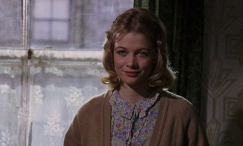 Movie still from “10 Rillington Place” (1971), directed by Richard Fleischer – A young woman in a floral print shirt and a sweater; Close Up shot, Over the shoulder angle