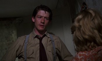 Movie still from “10 Rillington Place” (1971), directed by Richard Fleischer – A man wearing a brown shirt and a red tie; Close Up shot, Low angle