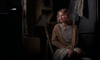 Movie still from “10 Rillington Place” (1971), directed by Richard Fleischer – A woman sitting on a chair in a room; Medium shot, Over the shoulder angle