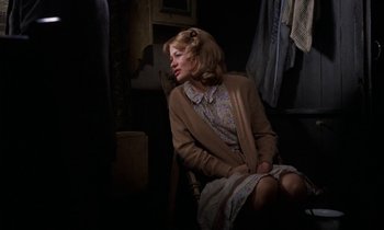 Movie still from “10 Rillington Place” (1971), directed by Richard Fleischer – A woman sitting on a chair in a dark room; Medium shot, Over the shoulder angle
