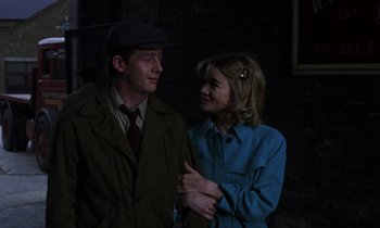 Movie still from “10 Rillington Place” (1971), directed by Richard Fleischer – A man and a woman standing next to each other in the dark; Close Up shot, Over the shoulder angle