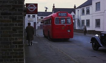 Movie still from “10 Rillington Place” (1971), directed by Richard Fleischer – A red bus driving down a street next to buildings; Wide shot, High angle