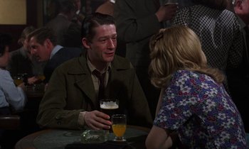 Movie still from “10 Rillington Place” (1971), directed by Richard Fleischer – A man and a woman sitting at a table with drinks; Medium shot, Over the shoulder angle