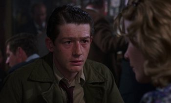 Movie still from “10 Rillington Place” (1971), directed by Richard Fleischer – A man in a brown jacket looking at a woman in a green jacket; Close Up shot, Over the shoulder angle