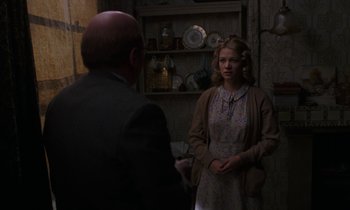 Movie still from “10 Rillington Place” (1971), directed by Richard Fleischer – A man and a woman standing in front of a shelf; Medium shot, Over the shoulder angle