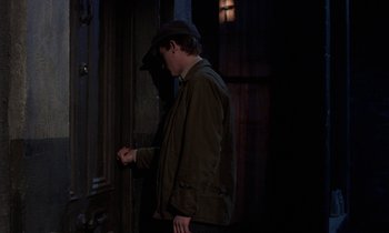 Movie still from “10 Rillington Place” (1971), directed by Richard Fleischer – A man standing in front of an open door at night; Medium shot, Over the shoulder angle