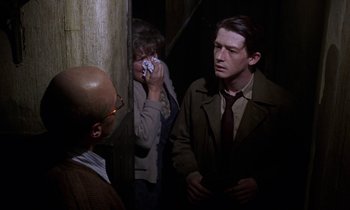 Movie still from “10 Rillington Place” (1971), directed by Richard Fleischer – A group of people standing next to each other in a room; Medium shot, Over the shoulder angle