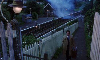 Movie still from “10 Rillington Place” (1971), directed by Richard Fleischer – A man standing on the side of a train track next to train tracks; Wide shot, High angle
