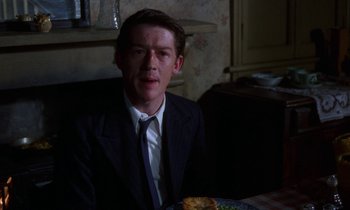Movie still from “10 Rillington Place” (1971), directed by Richard Fleischer – A man sitting at a table with food in front of him; Close Up shot, High angle