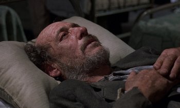 Movie still from “10 Rillington Place” (1971), directed by Richard Fleischer – An older man laying on a couch with his head resting on a pillow; Close Up shot, High angle