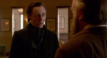 Movie still from “Crimson Peak” (2015), directed by Guillermo del Toro – A man talking to another man in front of a window; Medium shot, Over the shoulder angle