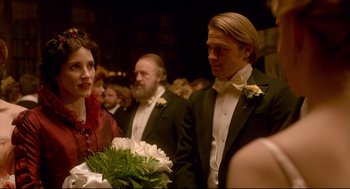 Movie still from “Crimson Peak” (2015), directed by Guillermo del Toro – A man and a woman in formal attire holding flowers; Medium shot, Over the shoulder angle