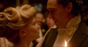 Movie still from “Crimson Peak” (2015), directed by Guillermo del Toro – A man and a woman in formal wear looking at each other; Close Up shot, Low angle