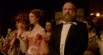 A man and a woman standing next to each other in formal wear