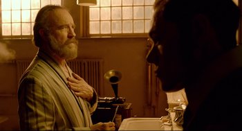 Movie still from “Crimson Peak” (2015), directed by Guillermo del Toro – An older man is looking at a younger man in a bathroom; Medium shot, Over the shoulder angle