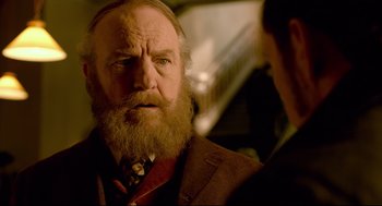 Movie still from “Crimson Peak” (2015), directed by Guillermo del Toro – An old man with a beard and a suit; Close Up shot, Over the shoulder angle