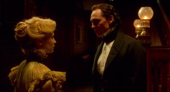 Movie still from “Crimson Peak” (2015), directed by Guillermo del Toro – A man and a woman standing next to each other in a room; Medium shot, Over the shoulder angle