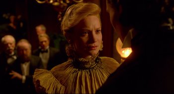 Movie still from “Crimson Peak” (2015), directed by Guillermo del Toro – A woman in a yellow dress is looking at a candle; Close Up shot, Over the shoulder angle