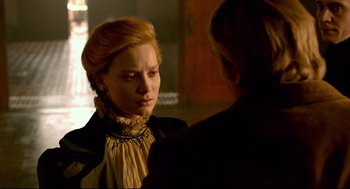 Movie still from “Crimson Peak” (2015), directed by Guillermo del Toro – A woman in a black and white dress talking to another woman; Close Up shot, Over the shoulder angle