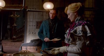 Movie still from “Crimson Peak” (2015), directed by Guillermo del Toro – A man and a woman standing in front of a pan; Medium shot, Over the shoulder angle