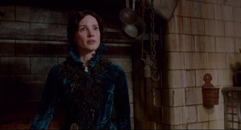 Movie still from “Crimson Peak” (2015), directed by Guillermo del Toro – A woman standing in front of a brick wall; Medium shot, Over the shoulder angle