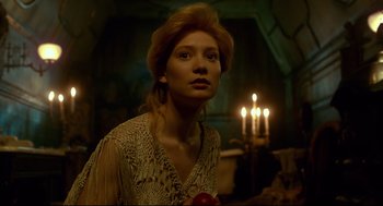 Movie still from “Crimson Peak” (2015), directed by Guillermo del Toro – A woman with a red apple standing in front of candles; Close Up shot, Low angle