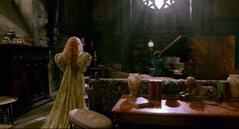 Movie still from “Crimson Peak” (2015), directed by Guillermo del Toro – Two people in a living room with a couch and a table; Wide shot, High angle