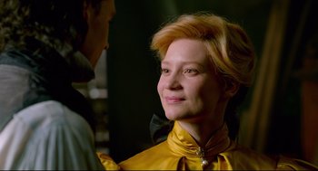 Movie still from “Crimson Peak” (2015), directed by Guillermo del Toro – A woman in a yellow dress smiling at the camera; Close Up shot, Over the shoulder angle