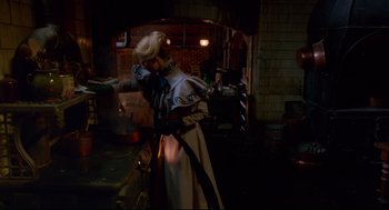 Movie still from “Crimson Peak” (2015), directed by Guillermo del Toro – A woman dressed in medieval garb is holding a sword in the dark; Wide shot, High angle