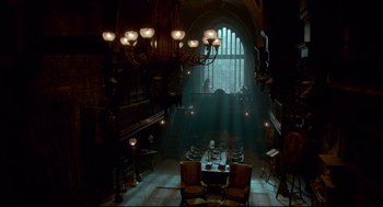 Movie still from “Crimson Peak” (2015), directed by Guillermo del Toro – A room filled with chairs and a table in front of a window; Extreme Wide shot, Low angle