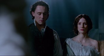 Movie still from “Crimson Peak” (2015), directed by Guillermo del Toro – A man and a woman standing next to each other; Medium shot, Over the shoulder angle