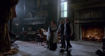 Movie still from “Crimson Peak” (2015), directed by Guillermo del Toro – A group of people standing around in a room; Wide shot, High angle