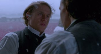 Movie still from “Crimson Peak” (2015), directed by Guillermo del Toro – A man standing next to another man in front of a snowy background; Close Up shot, Over the shoulder angle
