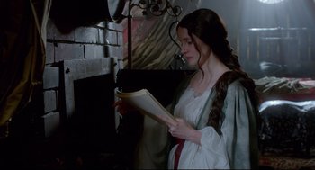 Movie still from “Crimson Peak” (2015), directed by Guillermo del Toro – A woman in a white dress is reading a paper; Medium shot, Over the shoulder angle