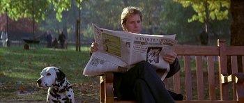 Movie still from “101 Dalmatians” (1996), directed by Stephen Herek – A man sitting in a chair reading a newspaper; Medium shot, Low angle