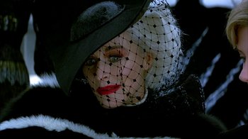Movie still from “101 Dalmatians” (1996), directed by Stephen Herek – A person wearing a hat with a veil; Close Up shot, Overhead angle