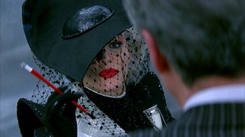 Movie still from “101 Dalmatians” (1996), directed by Stephen Herek – A woman in a black hat with a veil on her face; Extreme Close Up shot, Over the shoulder angle