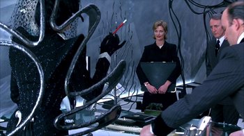 Movie still from “101 Dalmatians” (1996), directed by Stephen Herek – A woman standing in front of a group of people; Medium shot, Over the shoulder angle