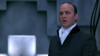 Movie still from “101 Dalmatians” (1996), directed by Stephen Herek – A man in a black and white striped jacket; Close Up shot, Low angle